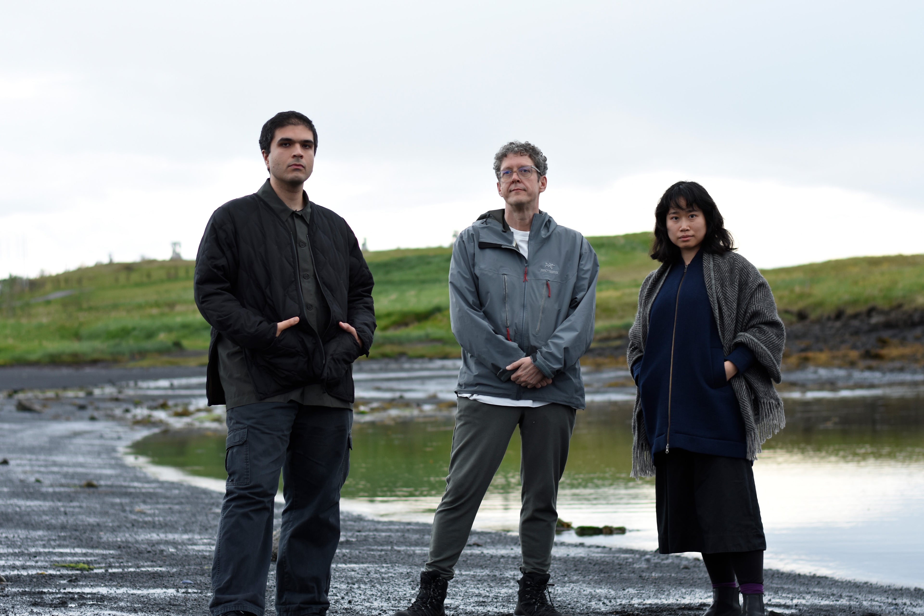 image of Kasra Goodarznezhad, Jerrold McGrath, and Luisa Ji standing by the beach in Reykjavik, Iceland posing for a very dramatic and serious photo.